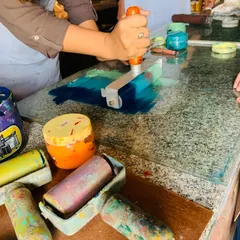 The magic of printmaking starts here. We guide students through the satisfying process of rolling vibrant, viscous inks onto a plate they designed themselves. This hands-on technique allows for endless experimentation with color blending and texture.