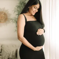 A classic and elegant maternity portrait. The simple black dress creates a timeless silhouette, focusing all the attention on the beautiful shape of your baby bump.