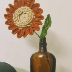 A single, rustic sunflower in a bottle, a reminder that it's okay to bloom alone. This handmade flower adds a touch of sunshine and warmth to any room.