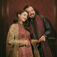 A happy, candid moment between the couple during their Sufi night. Their coordinated outfits in deep, rich tones are perfect for the theme.
