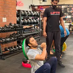 The coach-to-member ratio is key. Here you can see our coaches providing on-the-floor assistance, correcting form during weighted sit-ups and hip thrusts, and ensuring every member gets the attention they need.