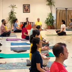 A group of teachers and students sit for meditation. The collective stillness in the room creates a powerful atmosphere for going inward.