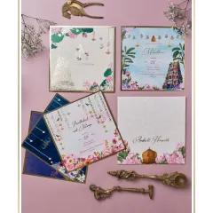 A vibrant South Indian wedding invitation suite. The design features custom illustrations of a temple gopuram, lotus ponds, and traditional motifs, all tied together with a bright and joyful color scheme.