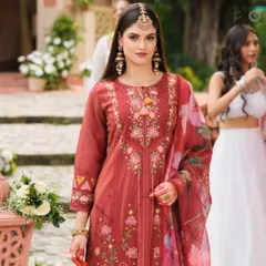 A model wears an elegant red Anarkali suit, perfectly accessorized with a statement maang tikka and jhumka earrings. Renting accessories is a great way to elevate a simpler outfit.