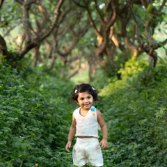 This toddler looks so confident and happy exploring this magical green pathway. I love capturing their adventurous spirit during outdoor photoshoots.