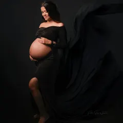A dramatic and elegant solo portrait in a black flowing gown against a black backdrop. This classic fine art style is truly timeless.