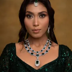 A close-up of a glamorous look perfect for a cocktail party or wedding reception. I used a blend of gold and brown eyeshadows to create a soft glam eye, paired with defined brows and a neutral lip, ensuring the focus remains on the client's radiant skin and stunning emerald jewelry.