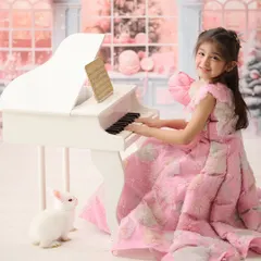 A little pianist in a beautiful pink gown, accompanied by a fluffy white bunny. We use charming props like this miniature grand piano to create whimsical scenes that spark joy and imagination.
