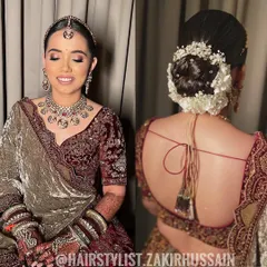 A classic bridal bun featuring a combination of white flowers and baby's breath. This style is perfect for a traditional wedding ceremony, providing a secure base for a veil or dupatta.