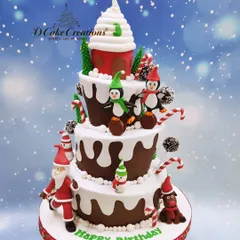 A whimsical, multi-tiered Christmas-themed birthday cake. This creation features playful penguins, candy canes, snow-dusted tiers, and a giant cupcake topper, perfect for a December birthday.