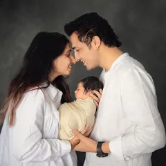 The beginning of a new family. This intimate portrait captures the pure love and happiness of new parents as they gaze at their precious newborn baby.