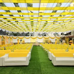 A wide view of a sunflower-themed Haldi setup. The canopy of yellow and white drapes, along with the matching seating, creates a bright, cohesive, and festive environment.