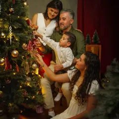 A beautiful family moment decorating the Christmas tree together. These are the memories that last a lifetime, captured in a warm, festive, and painterly style.