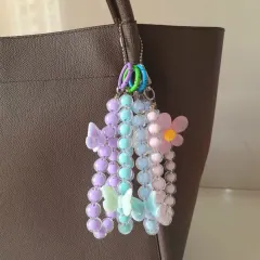 This multi-strand beaded charm adds so much personality to a simple tote bag. It features pastel purple, blue, and pink beads with delicate butterfly and flower charms for a dreamy, aesthetic look.