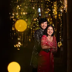 Pure happiness captured in a candid moment. The couple shares a laugh, surrounded by a magical backdrop of bokeh lights during their evening celebration.