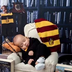 A classic shot of our little wizard sleeping in his chair, with his wand at the ready. The lighting creates a cozy, magical atmosphere.