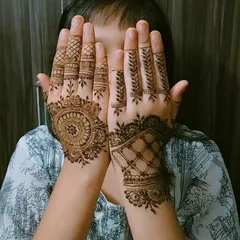 A cute and shy pose from a young client showing off her new henna. I can create a variety of designs that kids love, from simple mandalas to delicate finger patterns.