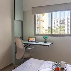 This bedroom features a sleek, wall-mounted desk by the window, creating a perfect work-from-home spot that doesn't take up valuable floor space.