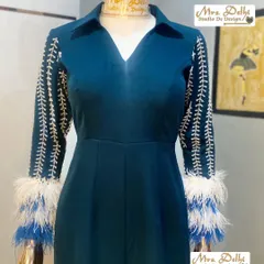 A stylish and royal hand-worked jumpsuit. This teal piece features intricate white embroidery on the sleeves, finished with dramatic white and blue feathers for a touch of glamour.