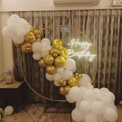 A simple and elegant white and gold balloon ring. This setup is perfect for a sophisticated celebration and can be placed in front of curtains or a plain wall.