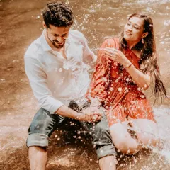 Pure, unscripted joy as a couple shares a laugh while splashing in a cool stream. This photo captures the fun, candid, and playful side of your relationship, making for truly authentic memories.