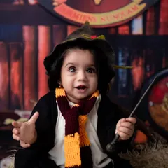 With a wand in hand and a look of wonder, this little wizard is ready to cast a spell. The sorting hat and Gryffindor scarf complete the look for an authentic Hogwarts portrait.