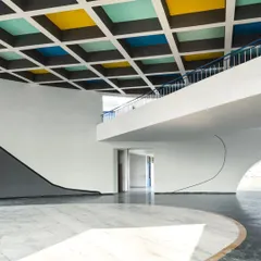 The interior of the school features clean lines, curved walls, and a beautiful interplay of light and shadow, creating a sophisticated yet child-friendly space.