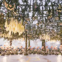 A breathtaking mandap setup with the Mumbai skyline as a backdrop. The ceiling was a dense canopy of hanging wisteria and roses, creating a natural yet luxurious sanctuary for the wedding ceremony.