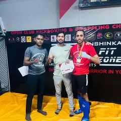 A student celebrates his first fight victory with his coaches. This is a huge milestone that is the result of months of dedicated training.