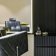 A closer look at the details of the cutting station. The diamond-patterned tufting on the leather chair complements the vertical lines of the black fluted cabinetry, creating a space that feels both luxurious and meticulously designed.