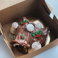 A close-up of the Yule log with its chocolate frosting, meringue mushrooms, and fondant holly.