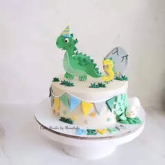 For a little dinosaur lover, I created this cute dinosaur themed cake. It features a friendly green dino in a party hat, a hatching egg, and colorful bunting.