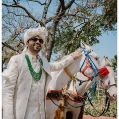 The groom arrives in style on a white horse for his Baraat, a classic and grand entrance for a North Indian wedding.