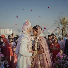 A tender kiss on the forehead right after the ceremony, with guests showering them with love and petals. It's these candid, emotional moments that truly define a wedding day.