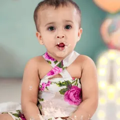 The best part of a cake smash is getting messy! This little girl is enjoying every moment, with cake on her face and hands.