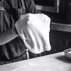 A playful dance of flour, fun, and fantastic flavors. Tossing the dough is a skill that takes practice, and it's mesmerizing to watch.