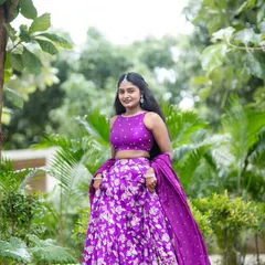 A happy client posing in her vibrant purple lehenga. I love how the color pops against the green background.