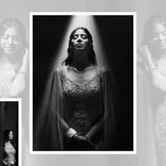 A dramatic black and white bridal portrait. The bride stands under a single spotlight, creating a powerful, artistic image that emphasizes her radiance.