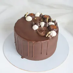 A delicious Chocolate Salted Caramel drip cake. This cake balances rich dark chocolate frosting with a sweet and savory salted caramel filling, decorated with chocolate spirals and meringue kisses.
