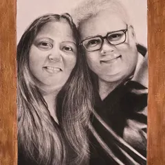 A custom portrait like this makes for a perfect and memorable gift. This charcoal drawing captures a warm moment between a couple, framed and ready to be cherished for years to come.