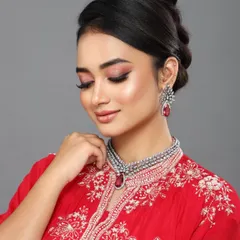 A beautiful shot of a model in a red gown. The makeup is soft and romantic, with a focus on pink tones and glowing skin, perfect for a fashion catalog or campaign.