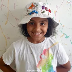 A young artist shows off the bucket hat she beautifully embroidered with colorful flowers. A unique, wearable piece of art.