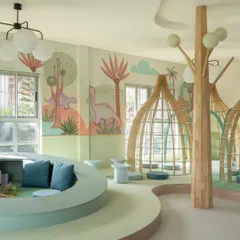 The nursery library is a world of its own, with curved, multi-level seating, tree-like columns, and dinosaur-themed murals. Every element is designed to spark imagination and make reading an exciting adventure.