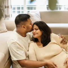 These are the moments to cherish forever. A sweet kiss on the forehead while relaxing on the floor at home. This is what lifestyle maternity photography is all about, capturing genuine connection and love.
