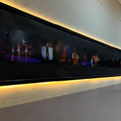 A close-up of our photo wall, lit up to inspire our dancers. It's a timeline of our journey and a preview of the memories you'll make with us.