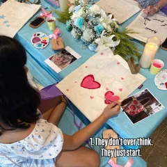 They don't overthink, they just start. This young artist is diving right into painting her tote bag, inspired by the photos and examples around her.