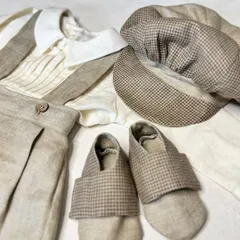 A touch of vintage magic for your little prince. This creamy beige suit set comes with a pleated shirt, suspenders, a classic cap, and handmade soft shoes.