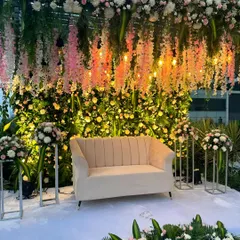 A gorgeous engagement stage with a lush backdrop of greenery and flowers. I used hanging wisteria and warm bulb lights to create a romantic and enchanting atmosphere.