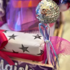 A mini disco ball wand adds a touch of glam and fun, perfectly capturing the popstar vibe.
