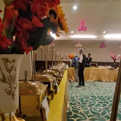Another view of our buffet line at an indoor party. The elegant floral arrangements and premium brass chafing dishes elevate the presentation for any occasion.
